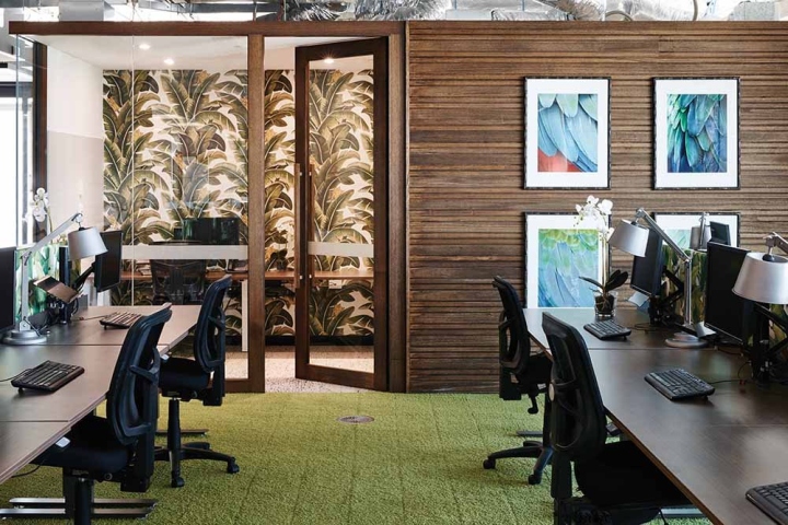 Природные цвета: коричневые деревянные панели на стенах и зеленый ковер в стильном оформлении интерьера офиса