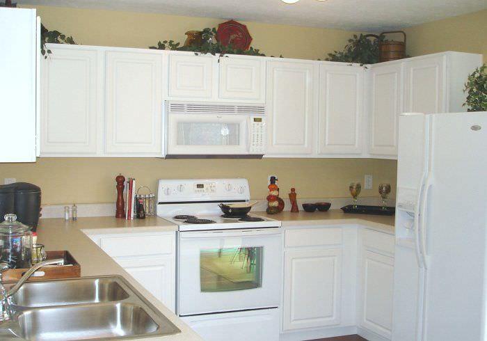 Если хотите сделать кухню визуально легче - откажитесь от верхних ящиков над невысоким холодильником