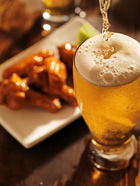 Лить пиво с куриные крылышки — стоковое фото