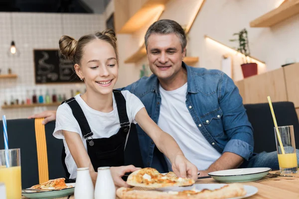 Отец и дочь, едят пиццу — стоковое фото