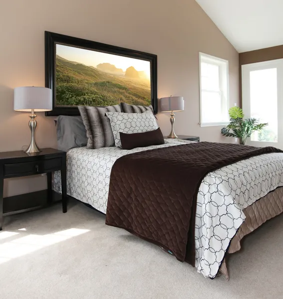 Современная коричнево-белая кровать с тумбочками — стоковое фото