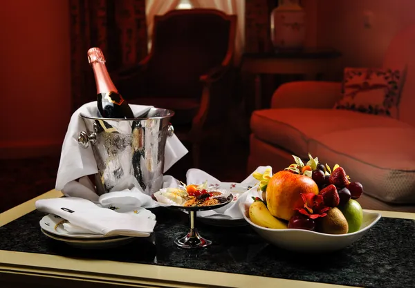 Романтический вечер с бутылкой шампанского, конфеты и фрукты в — стоковое фото