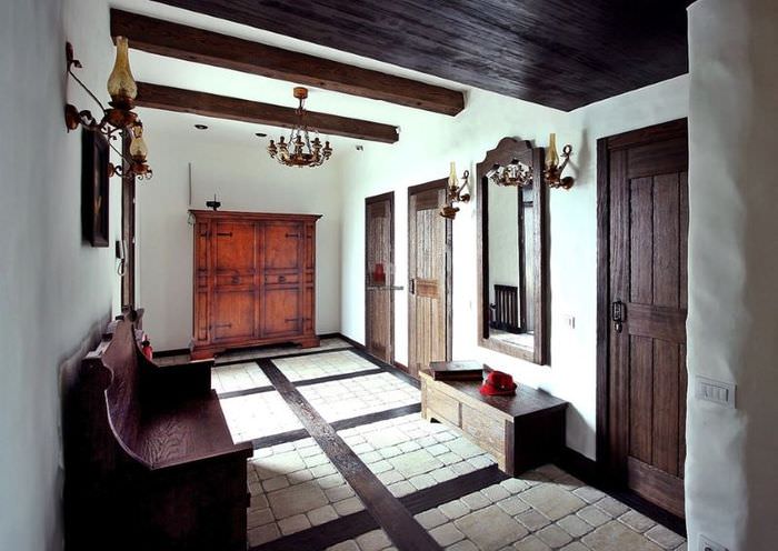 Прихожая чатного дома с деревянными дверями темного оттенка