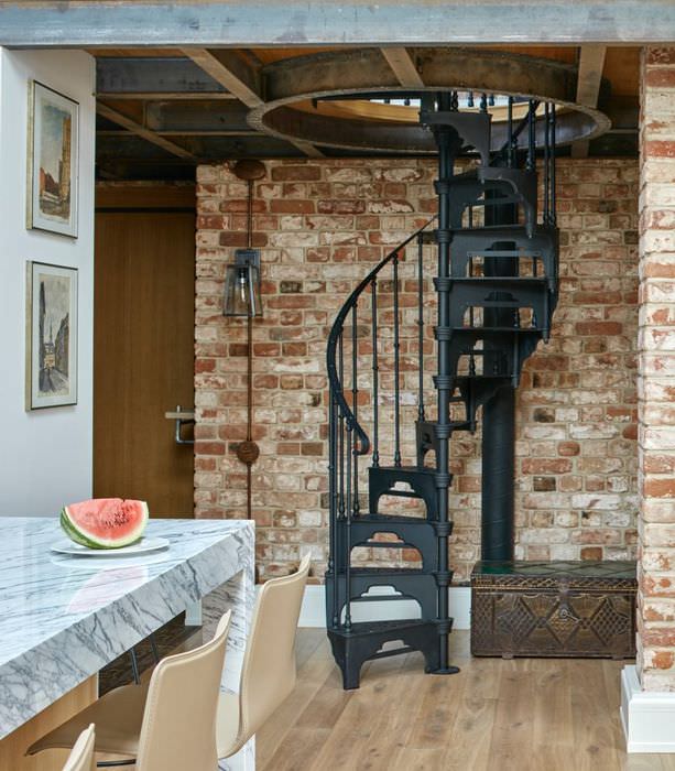 Винтовая лестница из черненного металла на второй этаж дома в стиле лофт