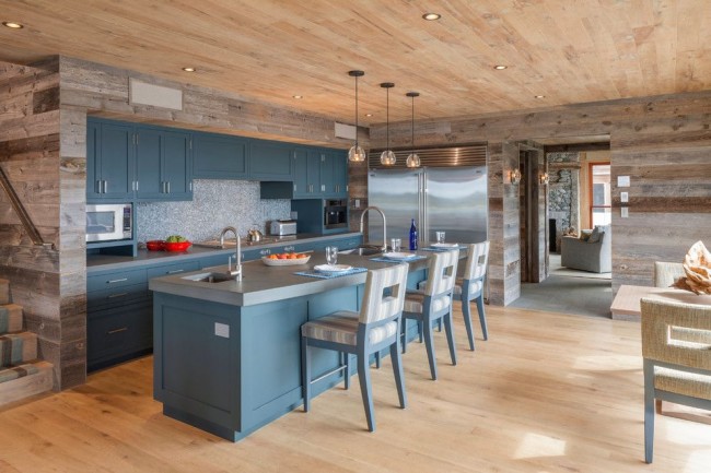 Голубая мебель и серо-бежевые тона деревянной обшивки на кухне