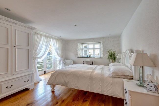 Светлая спальня в классическом стиле с белый полупрозрачными шторами