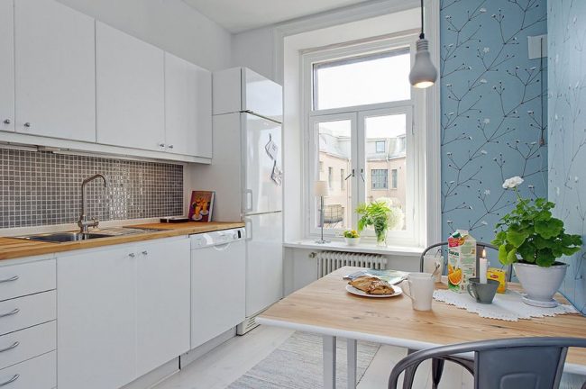 Современная белая кухня и голубые обои с рисунком выглядят достаточно стильно