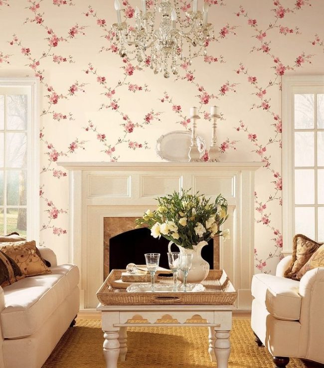 Романтичный цветочный рисунок на нежно-розовых обоях идеально подойдет для гостиной прованского направления