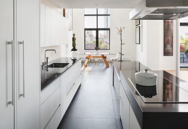 Перенос кухни в коридор позволяет расширить гостиную или обустроить просторную обеденную зону