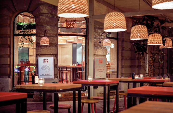 Деревянная мебель и плетеные светильники в интерьере ресторана в стиле модерн
