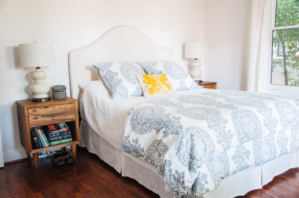 Элегантный интерьер белой спальни с винтажными прикроватными тумбочками