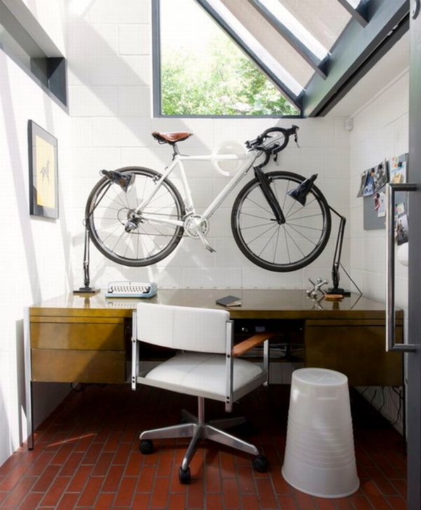 Домашний офис с наклонными окнами и велосипед на стене
