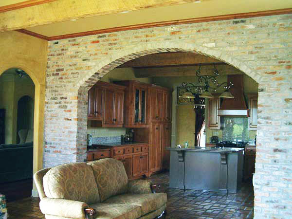 В качестве перегородки между кухней и гостиной из кирпича может выступать и арка, которая будет визуально делить пространство