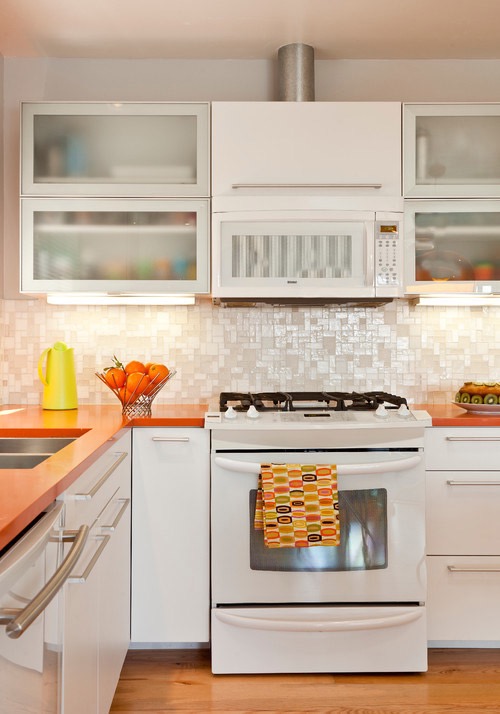 Белая кухня с оранжевыми поверхностями