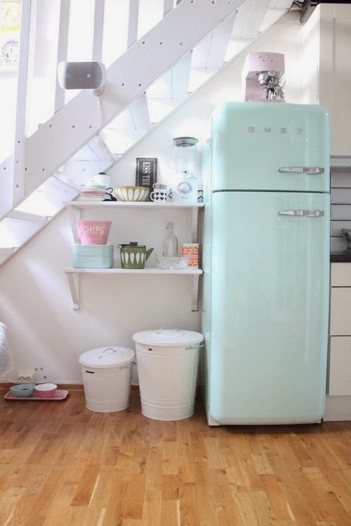 Яркий дизайн бирюзового ретро-холодильника SMEG в интерьере кухни под лестницей