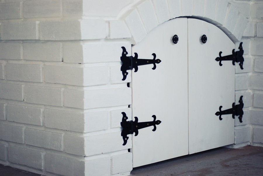 Дверцы шкафчика с узорными креплениями на летней кухне в деревенском стиле