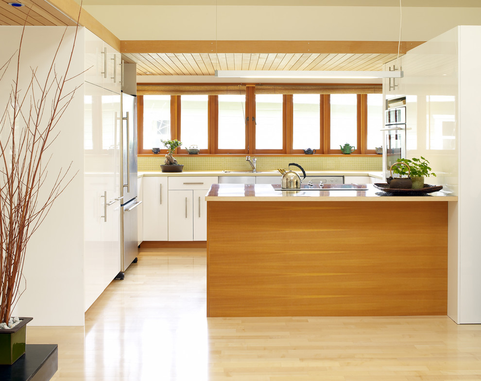Оригинальный дизайн интерьера белой кухни с деревянными акцентами от Works Photography Inc.