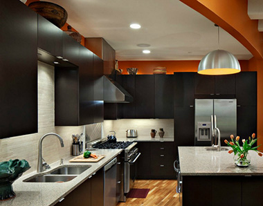 На коричневой кухне яркий оранжевый акцент можно сделать, выделив бытовую технику, декоративные панели, текстиль