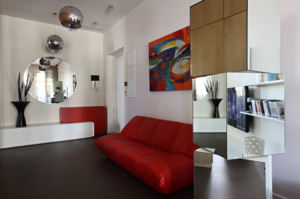 Комната для подростка с красным диваном и зеркальными поверхностями
