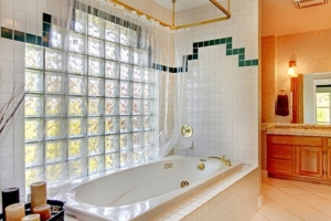 Ванная комната со стеной из стеклоблоков и ванной