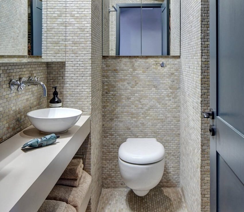 Пол и стены туалета оформлены плиткой из керамогранита