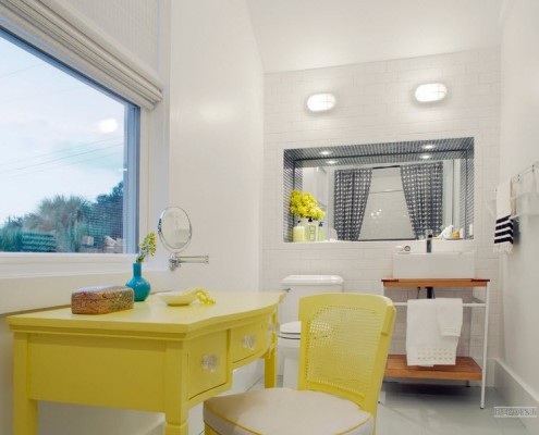 Желтый туалетный столик под окном в ванной