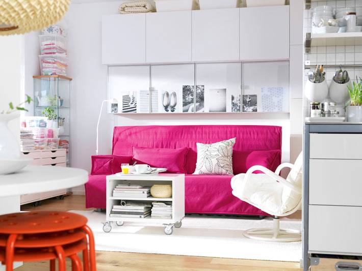 яркий розовый диван в белом интерьере кухни