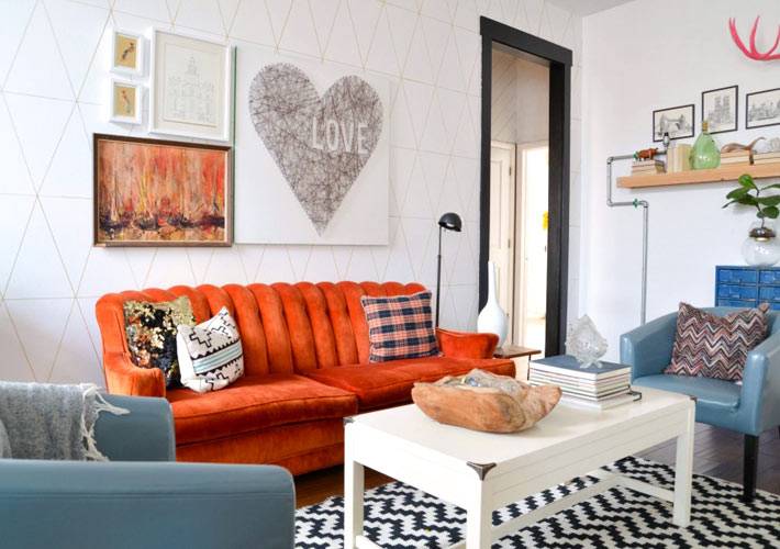 оранжевый диван и синие кресла в интерьере гостиной комнаты