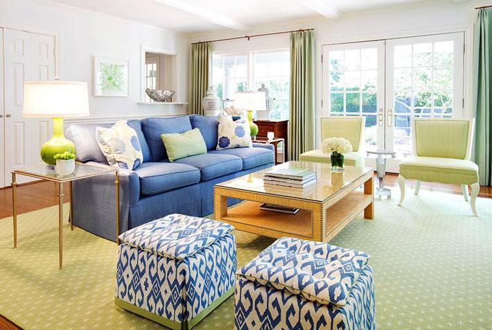 красивая гостиная комната с синим диваном и синими пуфами