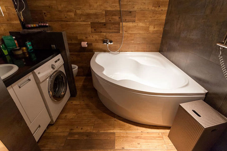 Угловая ванна позволяет сэкономить пространство. Интерьер в стиле лофт примечателен использованием отделочных материалов из дерева.