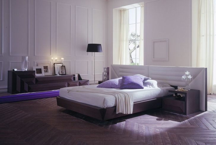 Спальня в стиле минимализм обставлена модульной мебелью. Грамотно подобранный свет делает комнату романтичной и уютной.