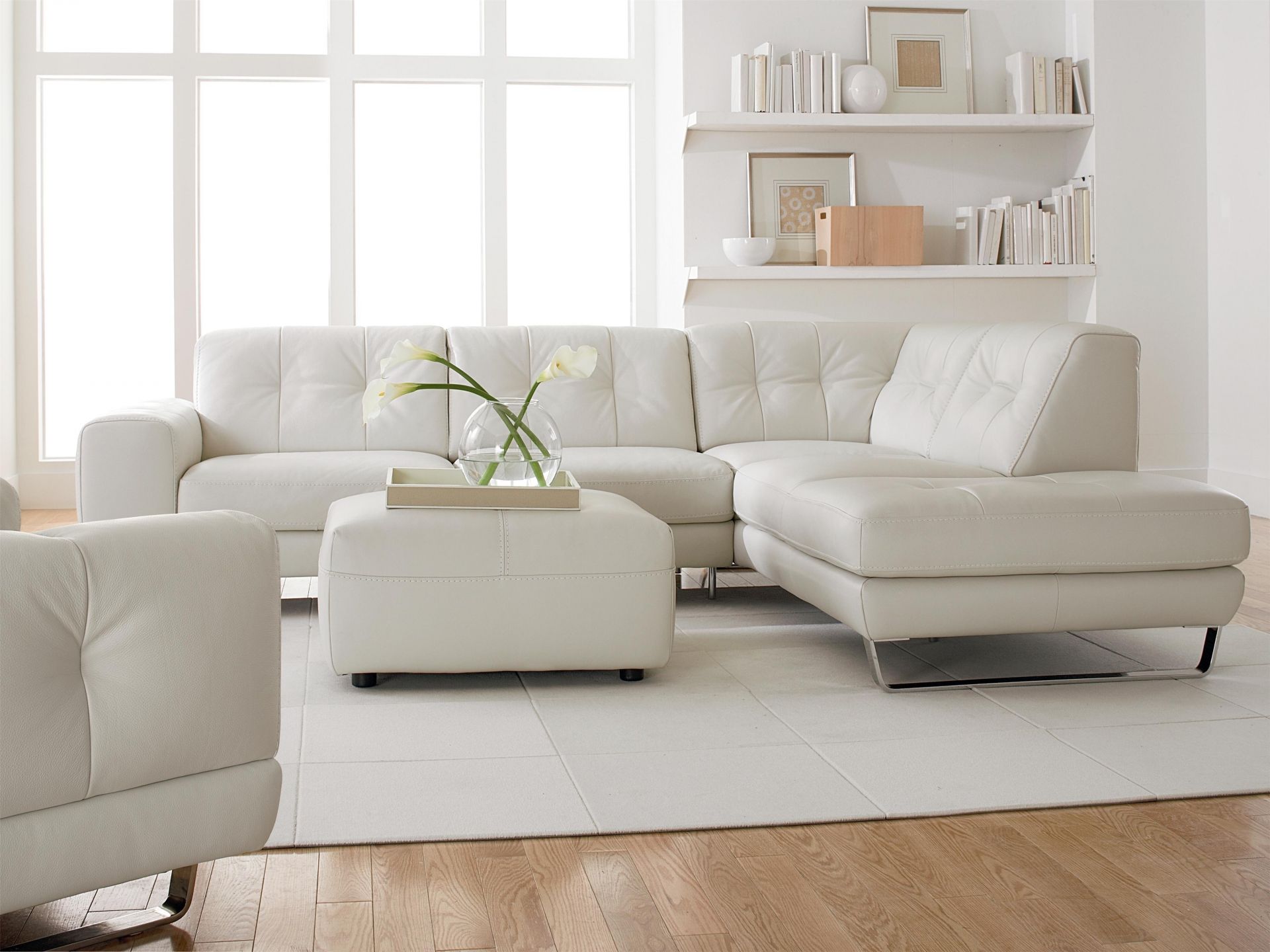 Белый кожаный угловой диван, кресло и пуф в интерьере