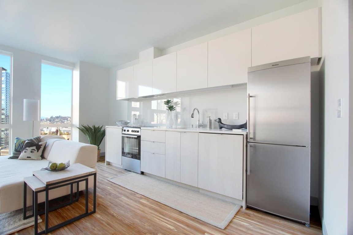 Белый кухонный гарнитур в совмещенной гостиной и кухне
