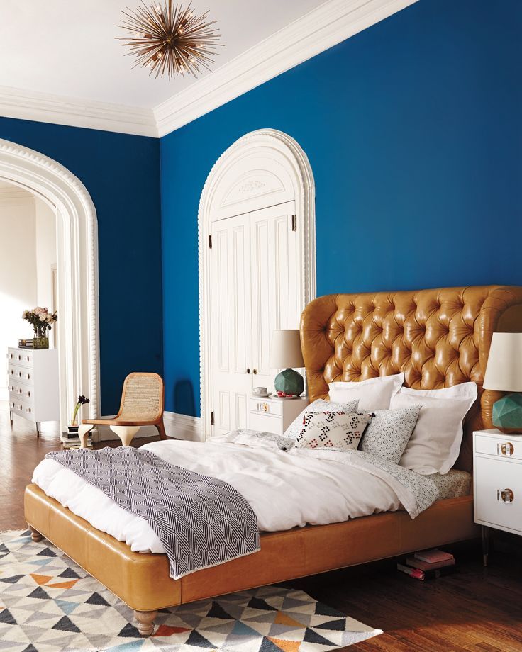 Коричневая кожаная кровать в бело-синей спальне