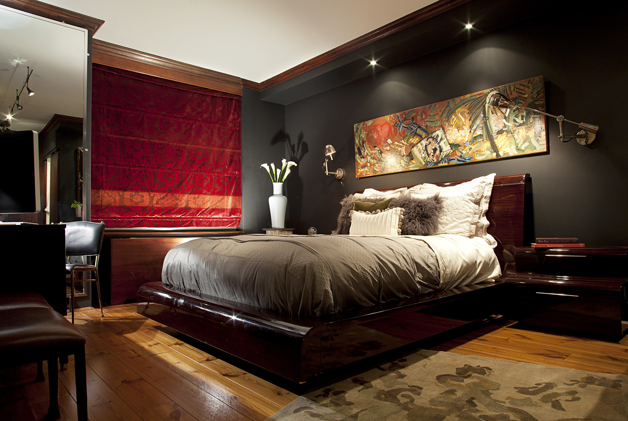 Точечное освещение и настенная лампа в спальне с красными шторами