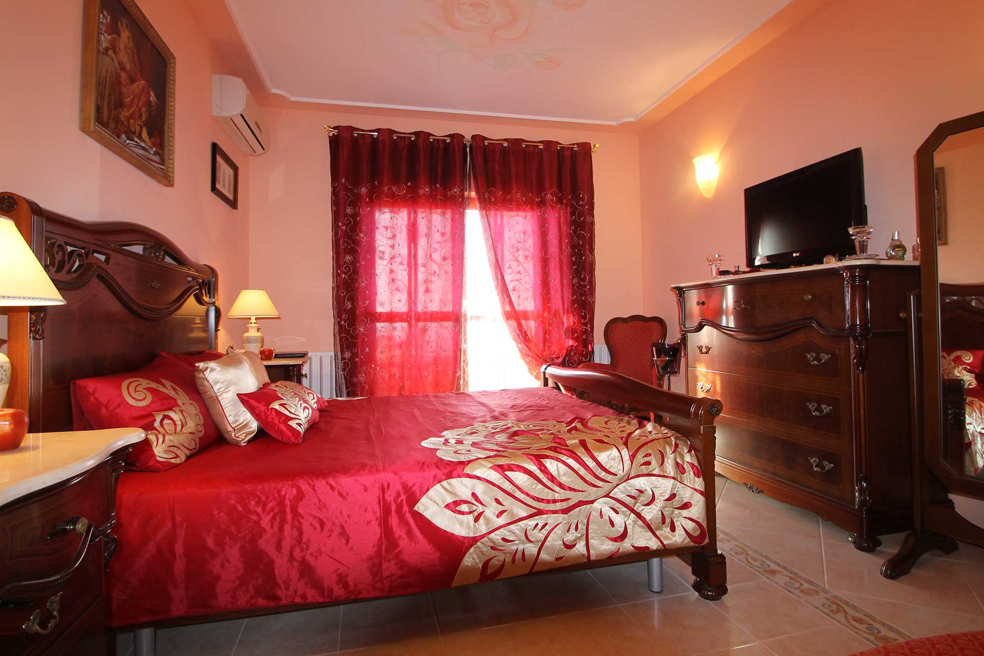 Красно-золотистые шторы и постельное белье в спальне