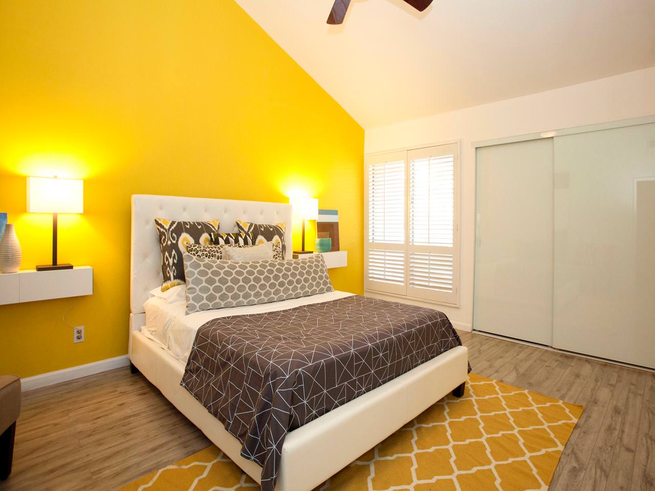 Спальня с желтой стеной в мансарде