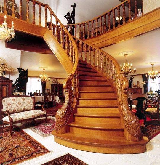 Парадная лестница загородного дома из дерева способна украсить любой интерьер.
