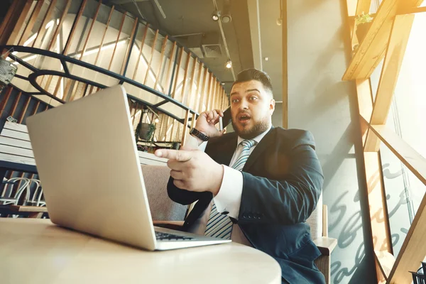 Портрет красивый бизнесмен разгневанного работы на своем ноутбуке, бушель — стоковое фото