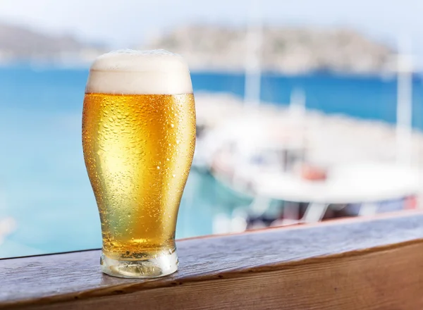 Стакан светлое пиво на море барная стойка. Лодки в doc — стоковое фото