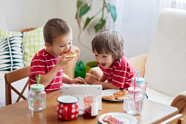 Две счастливые дети, двух братьев, имея здоровый завтрак сидя — стоковое фото