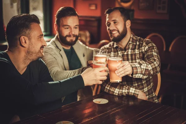 Веселые старые друзья весело и пить пиво в пабе — стоковое фото