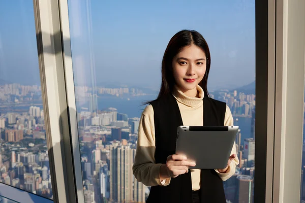 Young Asian woman is holding portable digital tablet — стоковое фото