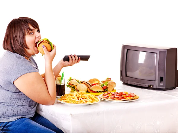Женщина, едящая фаст-фуд и смотрящая телевизор — стоковое фото
