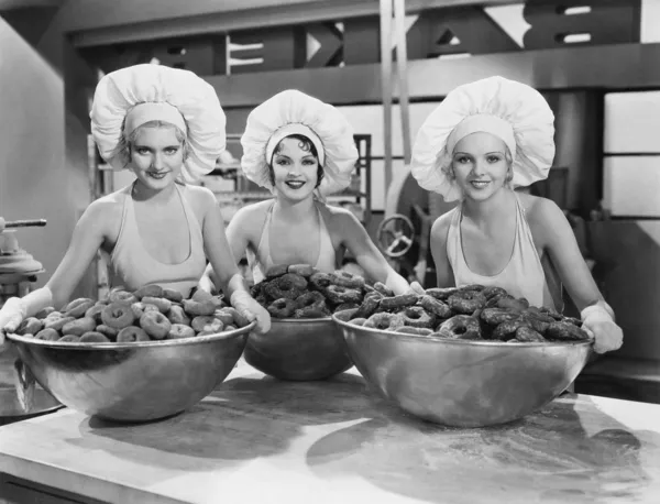 Три женщины с огромными чаши пончики — стоковое фото