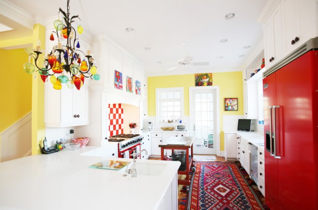 Просторная кухня, в которой соединены яркие цвета, которые особенно привлекательно выглядят, когда на нах попадает естественный свет